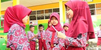 Siswa sedang menceritakan hasil bacaannya di hadapan teman-temannya dalam lomba membaca tiap minggu.